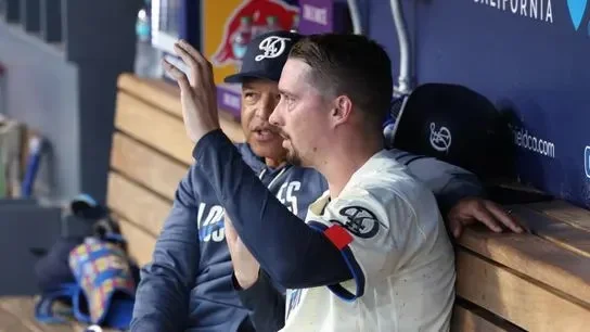 Los Angeles Dodgers pitcher Blake Snell (7) talks with manager Dave Roberts (30) in the dugout in the fourth inning against the Atlanta Braves at Dodger Stadium.