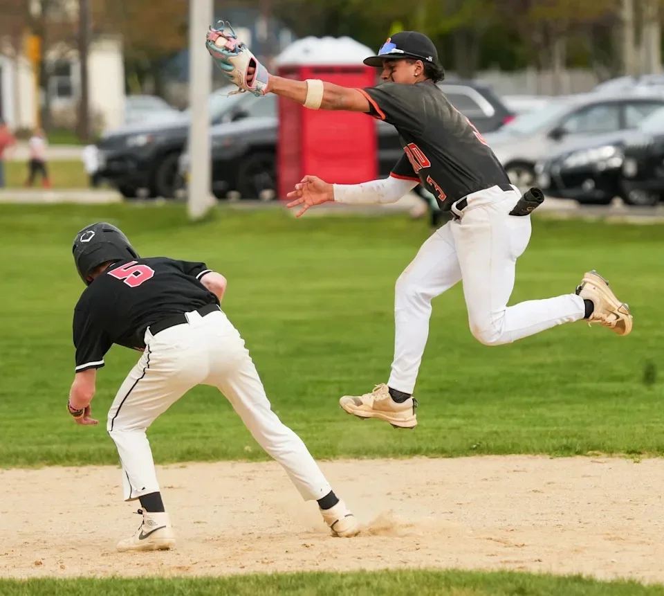 Oxford shortstop Jeff Guzman leaps for a high pickoff throw with South’s Noah Jolly on base April 29.
